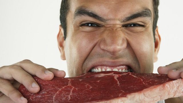 Hombre mordiendo carne cruda