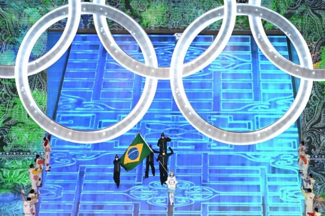 Jaqueline Mourão (izquierda) y Edson Luques Bindilatti (derecha) sostienen la bandera de Brasil.