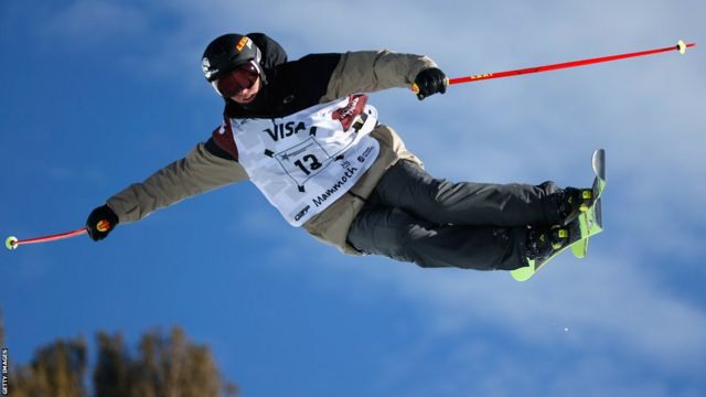 Kyle Smaine pictured flying high over a jump while competing in a freestyle skiing competition