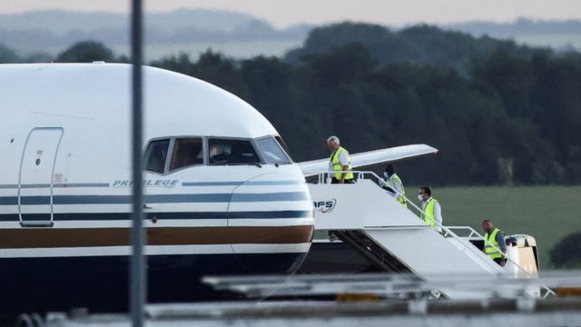 أعضاء الطاقم يستقلون طائرة ذكرت وسائل إعلام بريطانية أنها أول من ينقل مهاجرين إلى رواندا