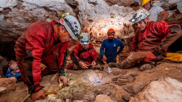 Arqueólogos del INAH observan fragmentos de cerámica.