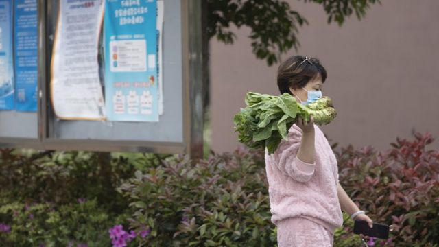 A woman carries vegetables in Shanghai on April 22 this year.