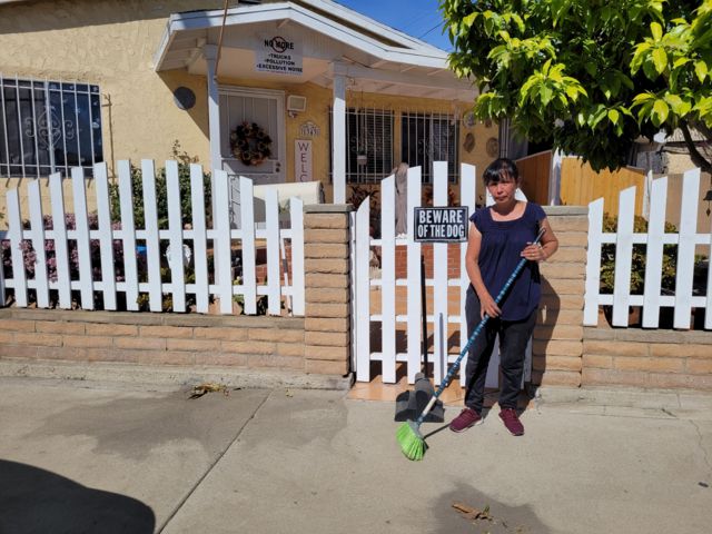 Imelda Ulloa sweeps in front of her house.