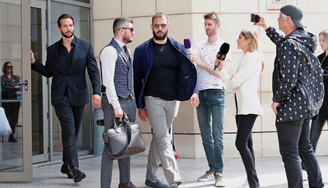 Andrew Tate y su hermano Tristan saliendo de la corte rodeados de prensa