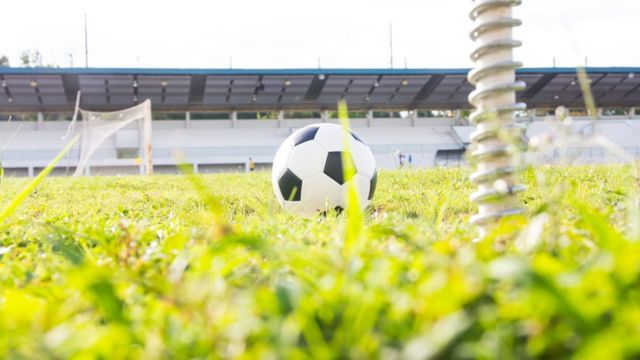 Em uma cobrança de falta em um jogo de futebol, o jogador tenta fazer com  que a bola faça um trajeto curvo, se desviando da barreira de jogadores  entre o ponto de