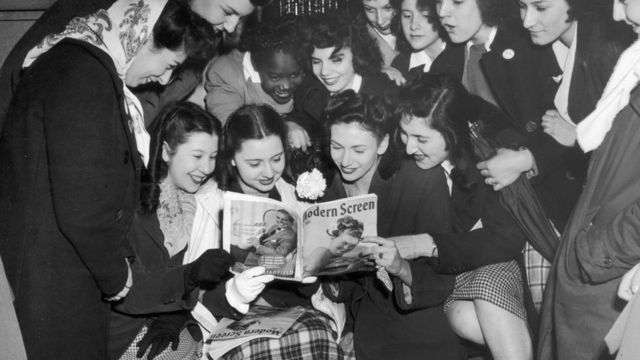 Un grupo de mujeres jóvenes lee una revista Modern Screen sobre farándula en 1950 en Nueva York.