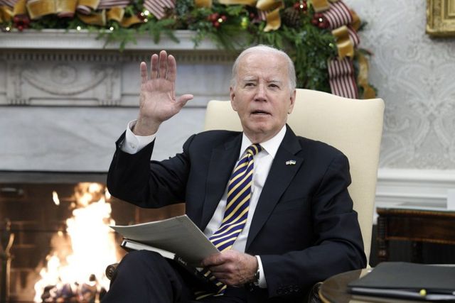 Biden gesticulando em frente a lareira