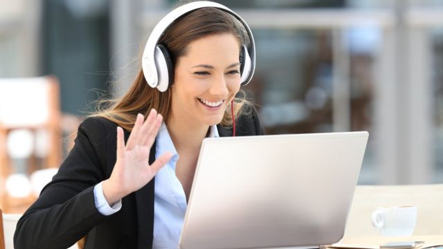 Mujer sonríe frente a computador