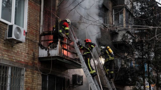 Bombeiros trabalham para apagar um incêndio em um prédio residencial atingido por um ataque de míssil russo, em meio ao ataque da Rússia à Ucrânia
