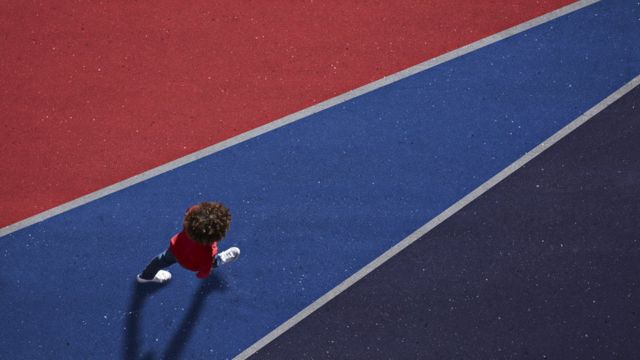 A child walks on a blue line