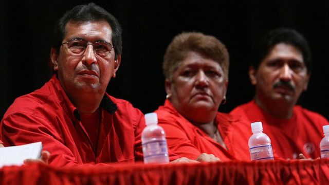 Adán Chávez and Arenis Chávez flank a woman at a meeting of the United Socialist Party of Venezuela.