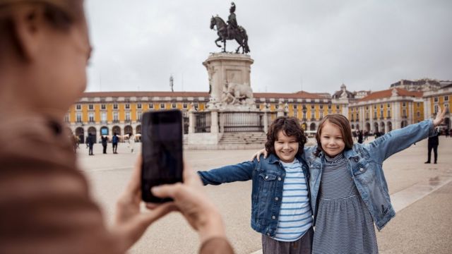 Una mujer toma una foto a sus hijos en la plaza del Comercio de Lisboa.