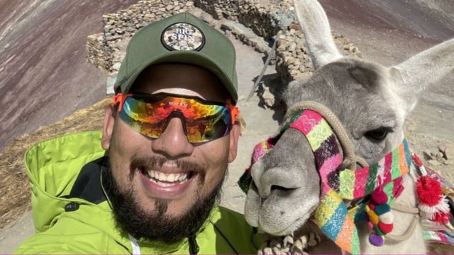 Chucho con una llama en los Andes.