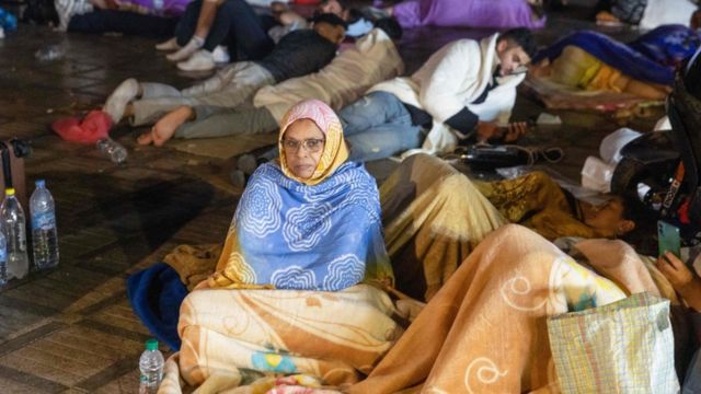 Seorang perempuan menghabiskan malam di luar rumahnya di Kota Marrakesh setelah gempa melanda.