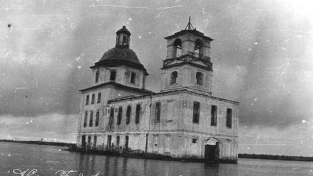 Imagem antiga de uma igreja com água cobrindo só uma parte da sua estrutura