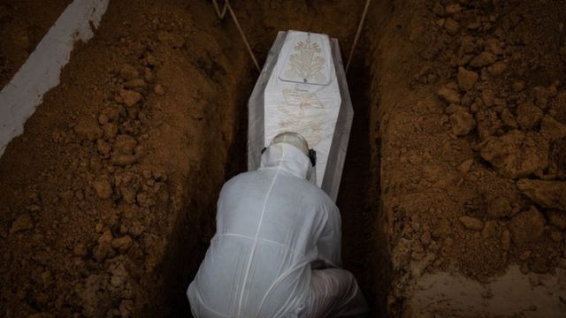 Caixão de vítima da covid-19 sendo enterrado em Manaus