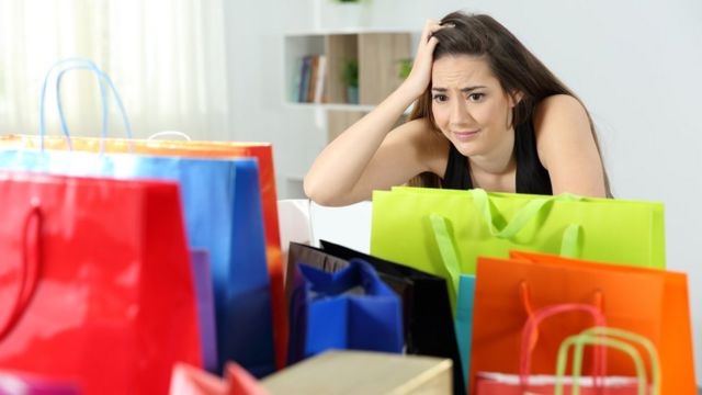 A young woman surrounded by shopping bags