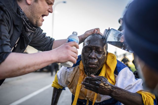 8. Fellow demonstrators wash a man's face after he was maced by police during protests resulting from the killing of an unarmed black man, George Floyd, by police