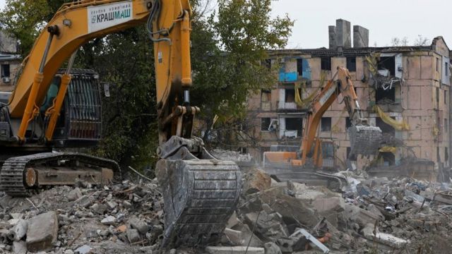 Экскаваторы убирают обломки разрушенного дома в Мариуполе