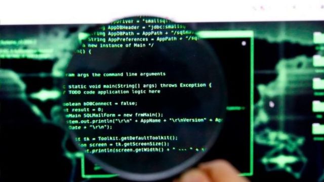 Magnifying glass on screen with programming codes