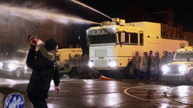 Objects are thrown towards PSNI officers and the water canon on Springfield Road in Belfast during further unrest