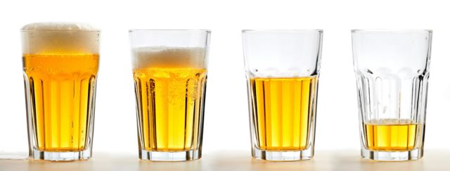 Quatro copos com quantidades decrescentes de cerveja