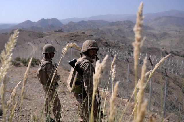 Tentara Pakistan berjaga di samping pagar perbatasan di Kitton Orchard Post di badan kesukuan Waziristan Utara Pakistan pada 18 Oktober 2017.