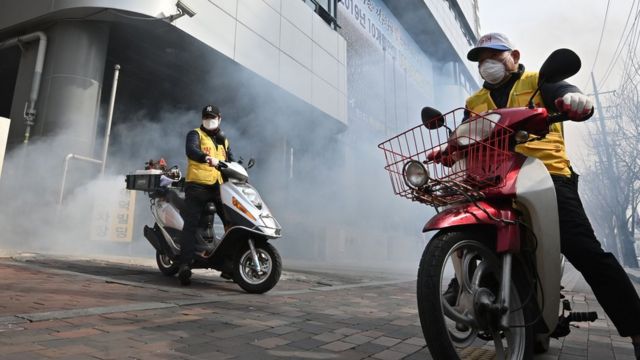當局在大邱市爆發集體感染的教會附近噴灑消毒劑。