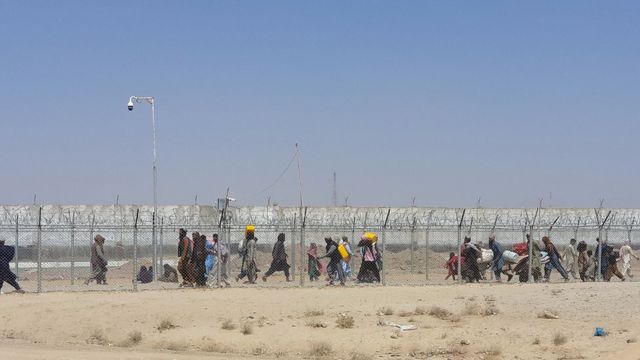 Afganos caminan entre las vallas en la frontera entre Afganistán y Pakistán