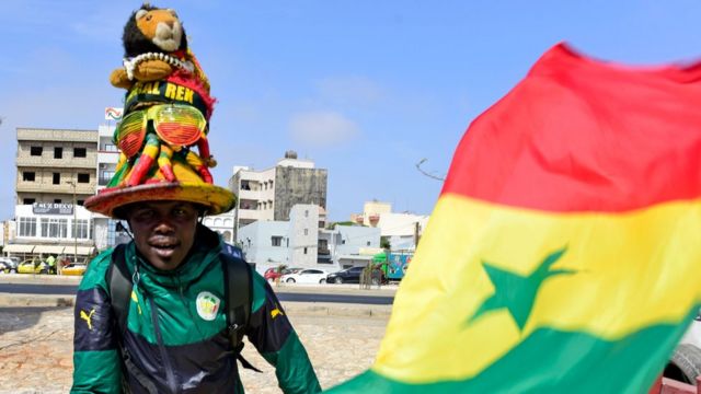 A supporter of Senegal's football team poses with the national flag in Dakar on May 17, 2018, during the announcement of squad members ahead of the forthcoming 2018 FIFA World Cup in Russia