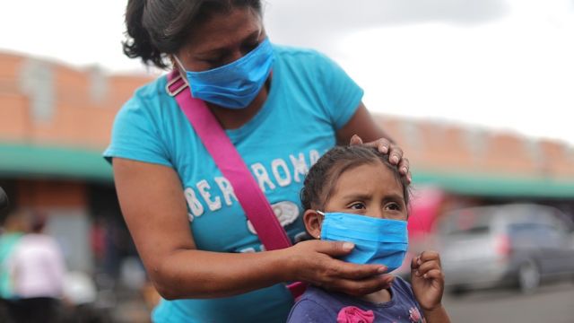 Madre con su hija en México. Ambas llevan tapabocas.