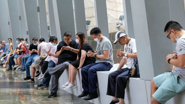 жители Гонконга обедают на подоконниках в офисном помещении