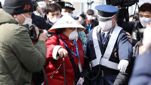 Японские полицейские сопровождают пассажиров лайнера "Даймонд принцесс"