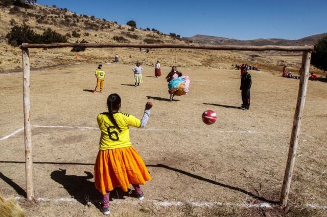 16 Temmuz 2022'de Peru'nun güneyindeki Puno'daki Juli bölgesinde yerli kadınlar bir şampiyona sırasında futbol oynuyor.