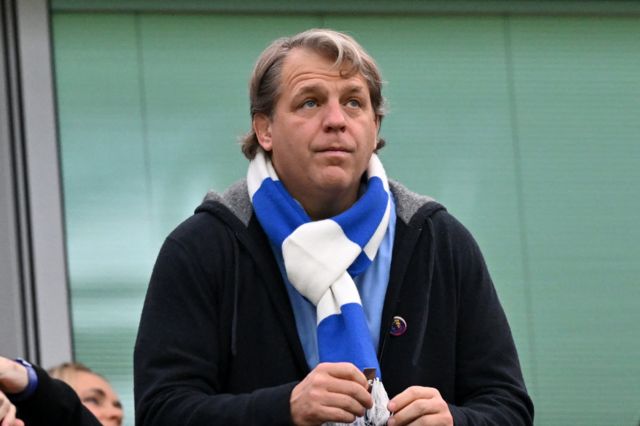 Todd Boehly in Chelsea scarf looks on from box
