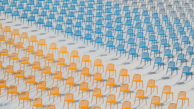 Fileiras de cadeiras coloridas vazias desertas em uma escola