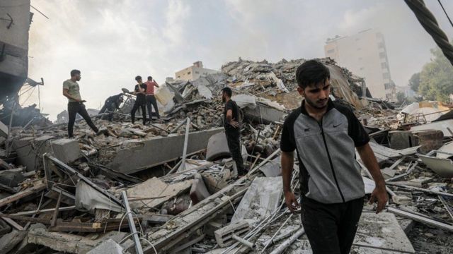 Palestinos inspeccionan los escombros de sus casas cerca de la Torre Watan en la ciudad de Gaza el 8 de octubre de 2023, tras los ataques aéreos israelíes.