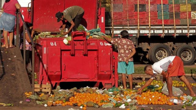 Люди копаются в отбросах овощей и фруктов, 4 ноября 2021 года