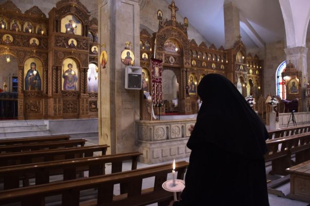راهبة تشارك في قداس بكنيسة في مدينة حلب شمالي سوريا