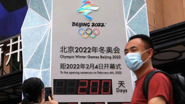 A woman uses her phone in front of a countdown clock showing 200 days to the opening of Beijing 2022 Winter Olympic Games, in Beijing, China July 19, 2021.