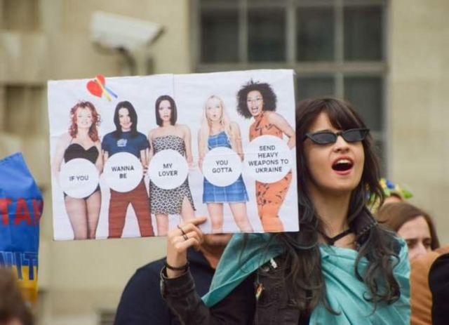 在伦敦，一名抗议者举着一张标有英国流行乐队辣妹乐队的标语牌，示威声援乌克兰(photo:BBC)
