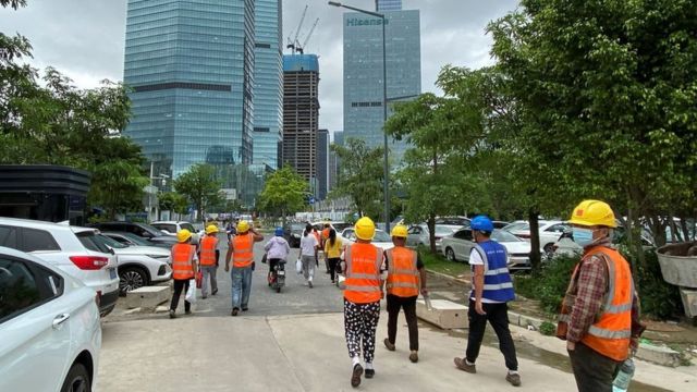 Công nhân xây dựng đi ngang qua các tòa nhà văn phòng ở quận Nam Sơn, Thâm Quyến, tỉnh Quảng Đông, Trung Quốc ngày 10 tháng 6 năm 2022