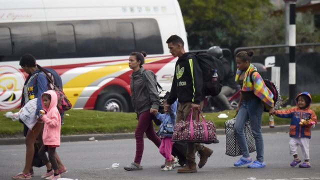 Venezuelanos saem de um terminal de ônibus em direção a um acampamento improvisado em Bogotá