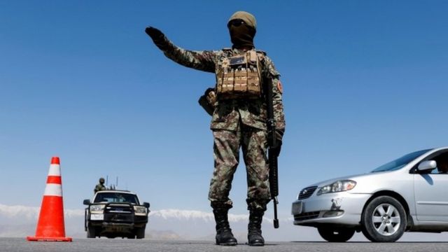 An Afghan National Army soldier stands guard at a checkpoint near Kabul in April 2021