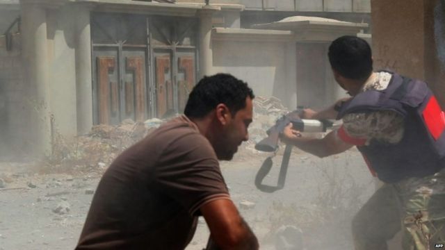 Pro-government fighters fire their weapons in the city of Sirte, Libya