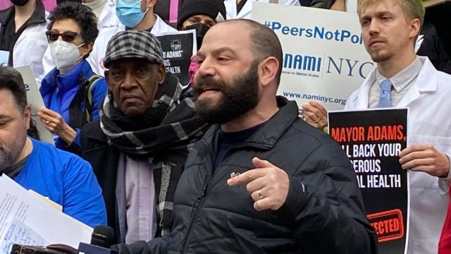 Matt speaking at the demonstration surrounded by others