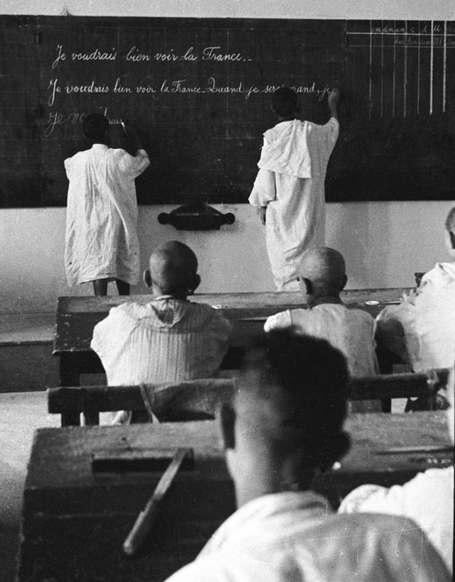 تلميذان جزائريان في فصل بمدرسة فرنسية خلال الخمسينيات يكتبان على سبورة سوداء: "أود أن أرى فرنسا عندما أكبر"