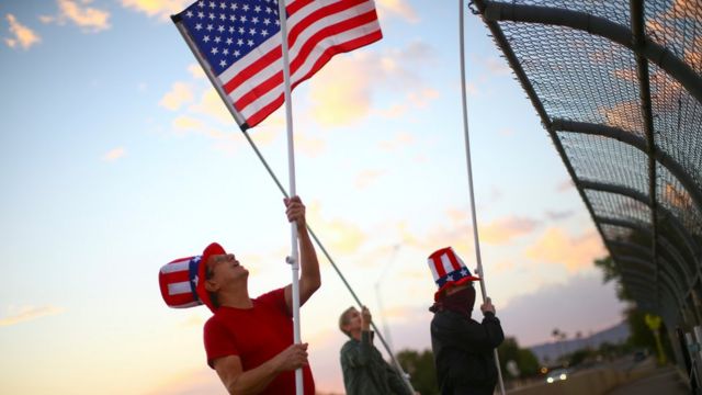 Voters wave American flags on a bridge in Phoenix on Election Day