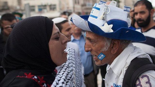 امرأة مؤيدة للفلسطينيين ورجل مؤيد لإسرائيل يصرخان على بعضهما البعض