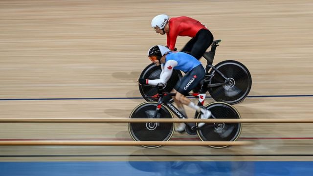 Россиянин Михаил Асташов (в красном) обходит канадца Тристена Чернова на пути к золоту на токийском велотреке